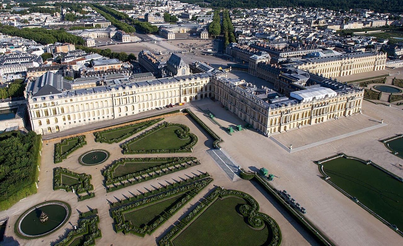 Slottet i Versailles med de symmetriske hageanleggene sett fra luften