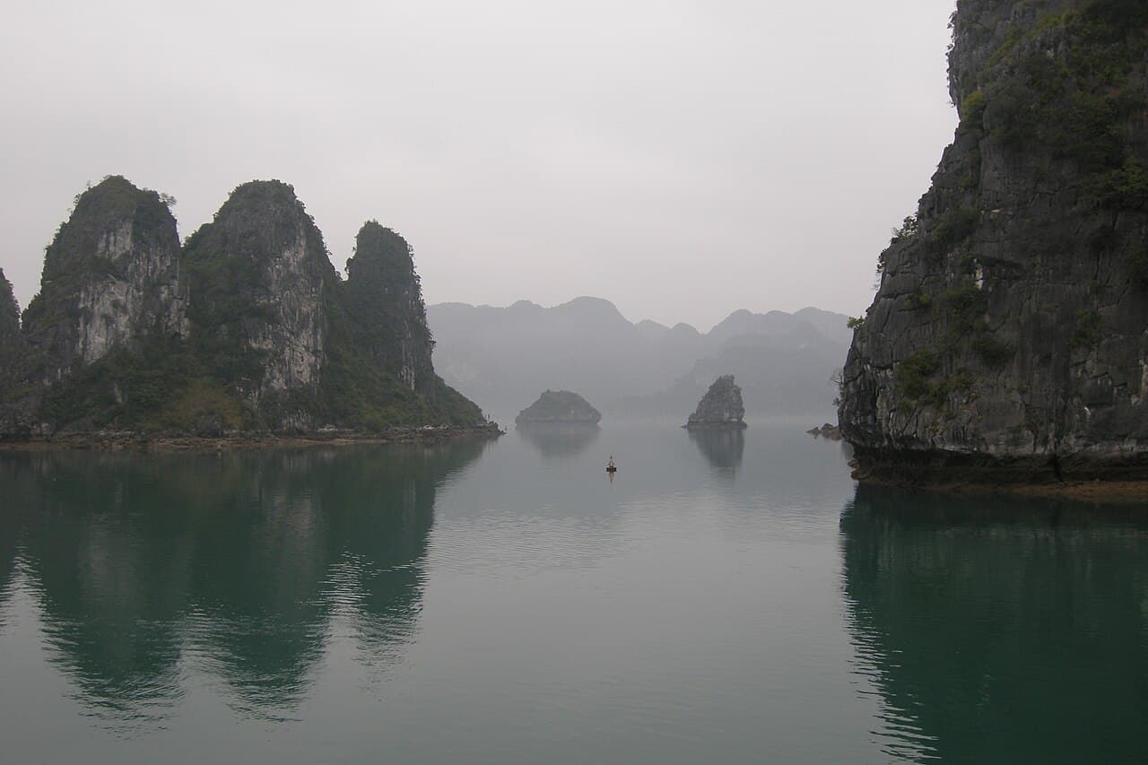 Kalksteinsøyer stiger opp av det grønne vannet i Ha Long-bukta