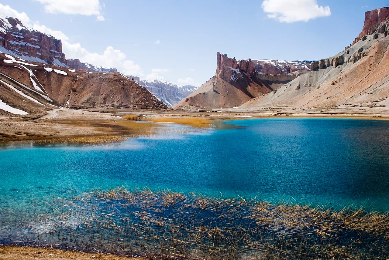 Dypblå innsjø omkranset av lyse klipper i Band-e Amir