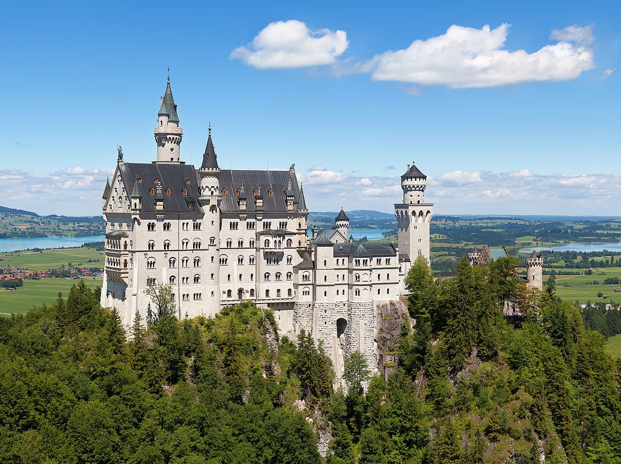 Slottet Neuschwanstein på en fjellknaus i Alpene
